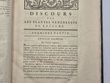 un livre ouvert posé sur une table blanche bordée de noir