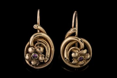 une photo d'une paire de boucles d'oreilles en or ornées de pierres violettes