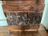 a wooden box with carvings on it sitting on a wooden floor