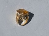 a gold ring with a tiger ' s eye on a white surface