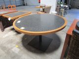 une table dont le plateau est noir et le piètement marron