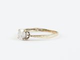 a close up of a diamond ring on a white surface