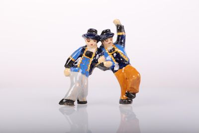 two figurines of two men standing next to each other