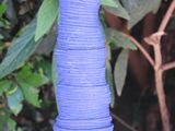 a blue vase that is sitting in the middle of a bush