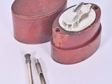 a small red box with a silver lid and a pair of scissors