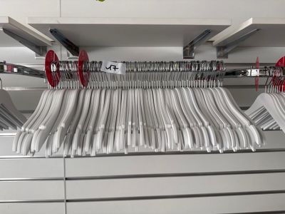 les nombreux cintres accrochés au mur du magasin