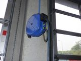 un tuyau bleu fixé sur le côté d'une porte de garage