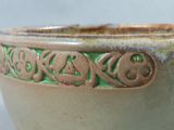 a close up of a green and brown bowl on a table