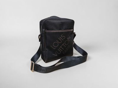 a black cross body bag sitting on top of a white surface