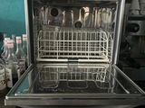 a dishwasher in the middle of a kitchen with a lot of utensils in it