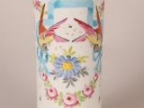 a white vase with birds and flowers painted on it