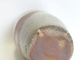 a close up of a small vase on a white surface