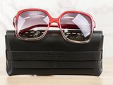 a pair of red sunglasses sitting on top of a black case