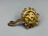 une plaque en laiton ornée d'une tête de lion, posée sur une table