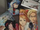 a lot of anime books sitting on a couch