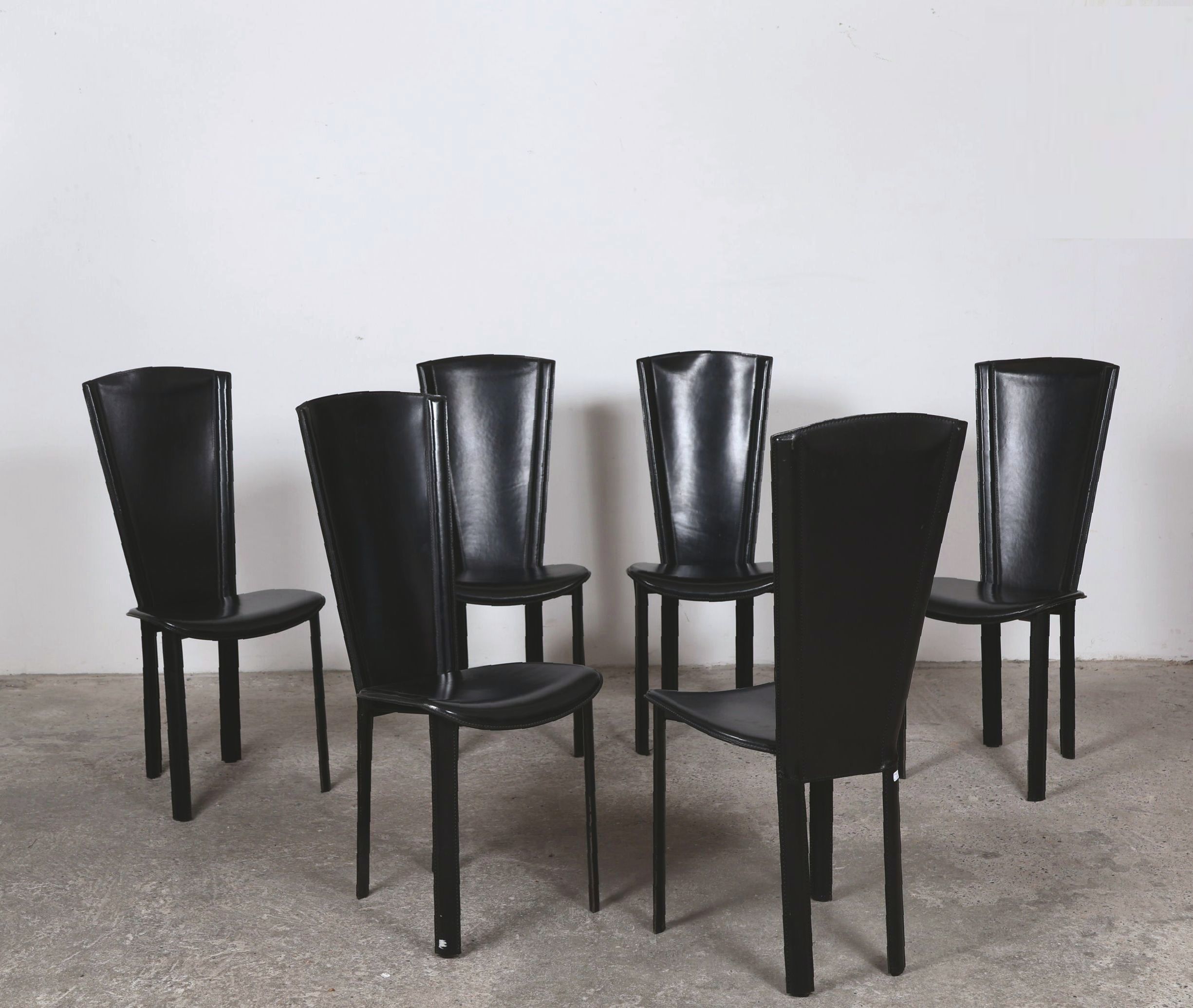 ROCHE BOBOIS, éditeur. Suite de six chaises à haut dossiers évasés, gainées de cuir noir. H_104 cm L_45 cm P_42 cm