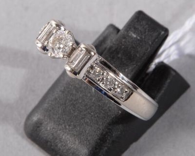 a picture of a three stone diamond ring on a ring stand