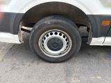 a white van with a flat tire parked in a parking lot