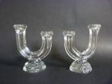 two clear glass candlesticks on a black background