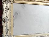 an ornate gold framed mirror sitting on top of a red carpet