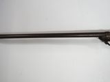 a rifle with a wooden barrel on a white surface