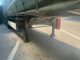 a man that is standing under a truck on the street