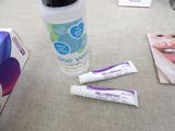 a bottle of toothpaste and two tubes of toothpaste next to a box of toothpaste
