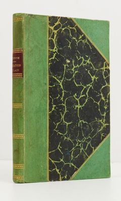 un livre vert et noir posé sur une table blanche