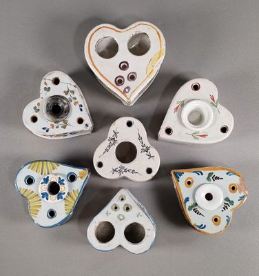 six bougeoirs en porcelaine en forme de cœur posés sur un support gris