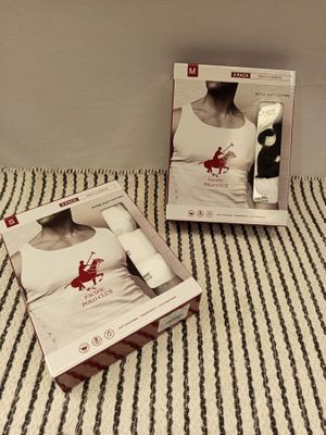 boxes on a bed with a woman ' s shirt and a man ' s shirt