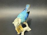 a figurine of a bird sitting on a branch