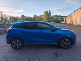 a blue car parked in a parking lot next to a building