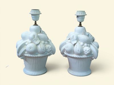 deux vases blancs décorés de fruits, posés sur une table