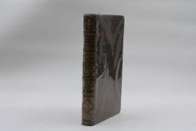 un vieux livre posé sur une table à côté d'un fond blanc