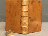 an old book with a gold cover and a pair of scissors