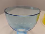 a blue glass cup sitting on a table next to a banana
