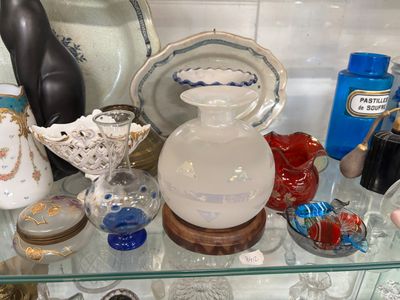 une étagère en verre sur laquelle sont disposés de nombreux vases en verre