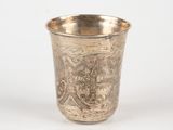 a silver cup with a design on it on a white surface