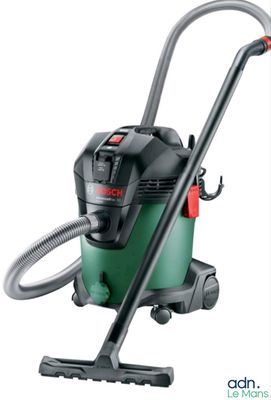 un aspirateur vert et noir muni d'un tuyau, sur fond blanc