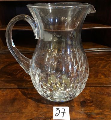 un pichet en verre posé sur une table, avec une étiquette de prix dessus