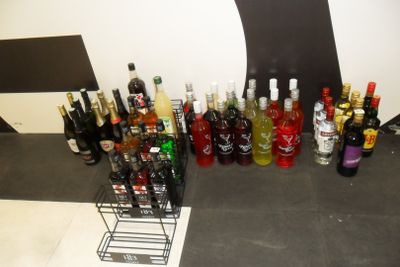 bottles of alcohol are lined up on a counter in front of a tree