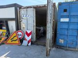 de nombreux panneaux et affiches devant un conteneur bleu