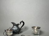 a silver tea pot and a silver tray on a table