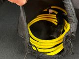 a person holding a bag with a bunch of hoses in it