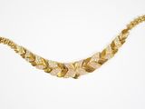 gros plan d'un collier en or sur fond blanc