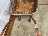 a wheelbarrow with dirt in it sitting on the ground
