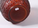 a brown vase with a brown lid sitting on a white surface
