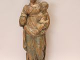 une statue ancienne d'une femme tenant un enfant dans ses bras