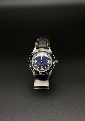 gros plan d'une montre sur une surface noire avec un fond noir