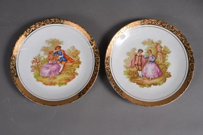 deux assiettes aux bords dorés, ornées d'un couple